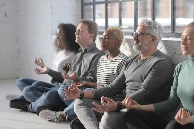 Colleagues taking a mindful wellbeing break together in a bright workplace. Illustrative photograph.